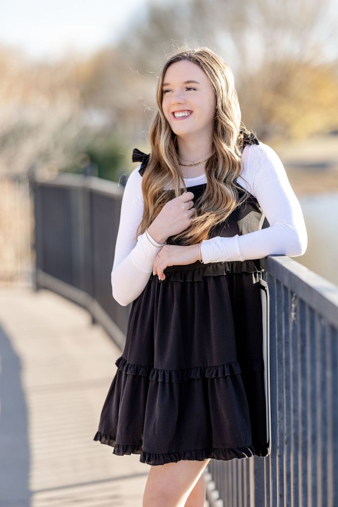 Senior portrait of girl in black dress with fall backdrop. Portrait by Lane and Mistie Photography in Midland TX.